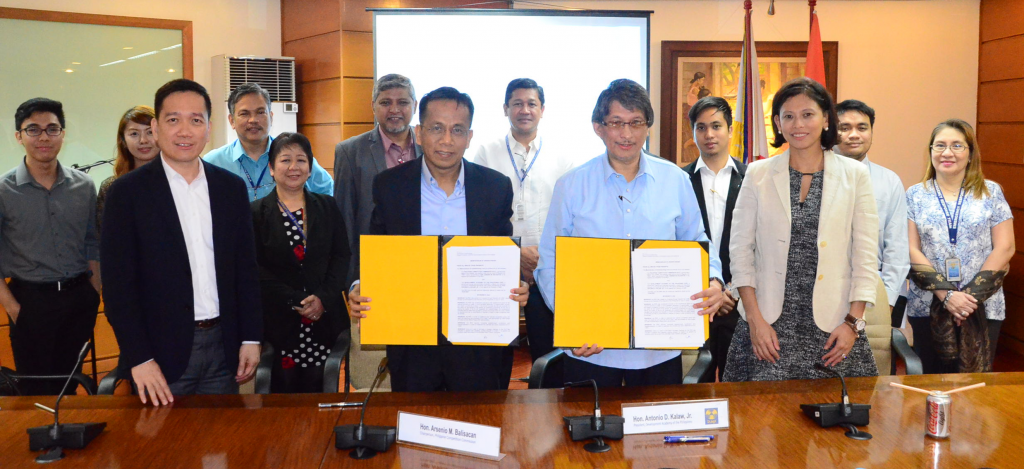 PCC Chairman Arsenio Balisacan (front row, second from left) and DAP President Antonio Kalaw Jr. show off the documents they signed after formalizing a partnership between the two agencies as PCC commissioners Johannes Bernabe (to Balisacan's right) and Stella Alabastro (to Kalaw's left) as well as other DAP and government officials witness.  That's NEDA Assistant Director-General Kenneth Tanate in between Balisacan and Kalaw on second row. 