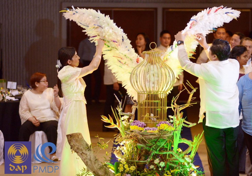 Living up.  Two members of MMC Batch 12 pin   feathers onto a  giant wing display as a symbol of their commitment to their goals as their batch mates look on.   (Liz Ranola)  